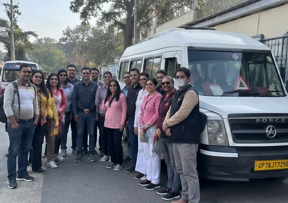 Travellers beside a Tempo Traveller before a road journey