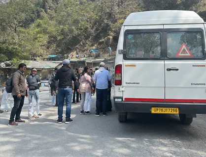 Travellers beside the group vehicle on a mountain road