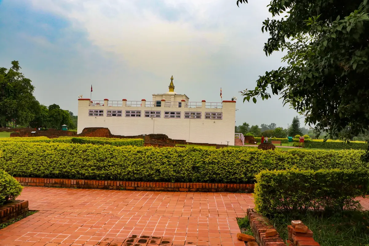 Maya Devi Temple in Lumbini behind green gardens and a brick walkway