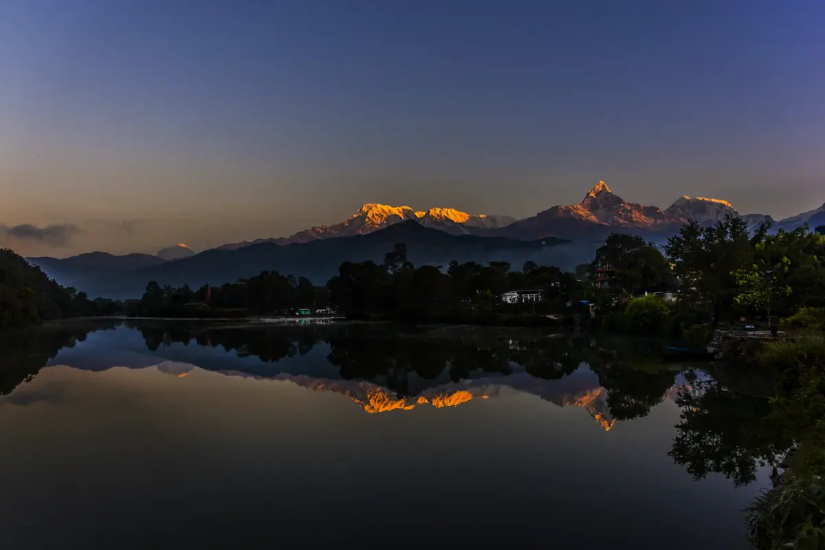 Annapurna mountains glowing at sunrise and reflected in Phewa Lake, Pokhara