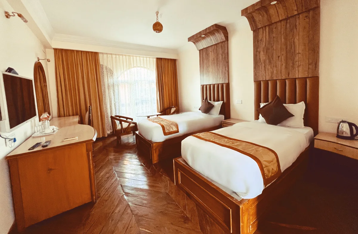 Twin-bed room with wood flooring from the supplied hotel collection